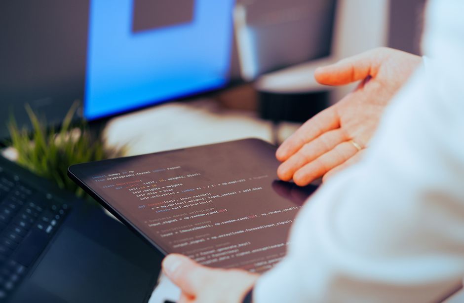Software developer coding with AI tools on a laptop