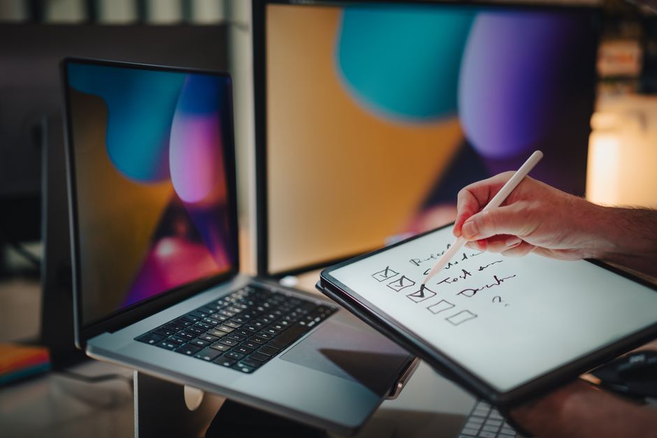 Researcher using two AI tools in parallel on dual monitors for a research project
