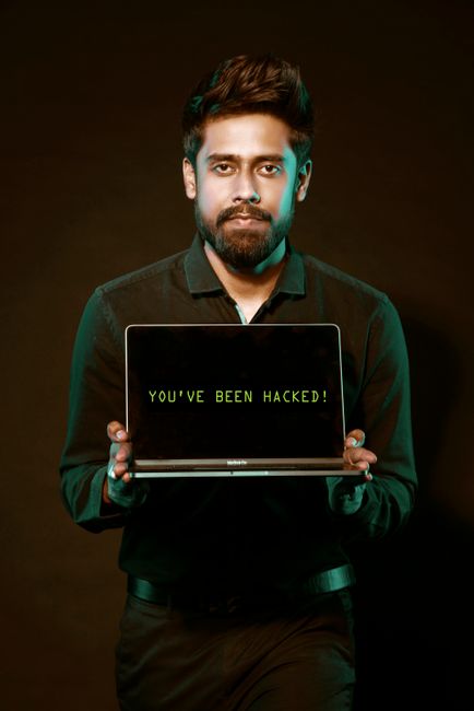 Hacker using a laptop to access social media accounts through an AI chatbot exploit