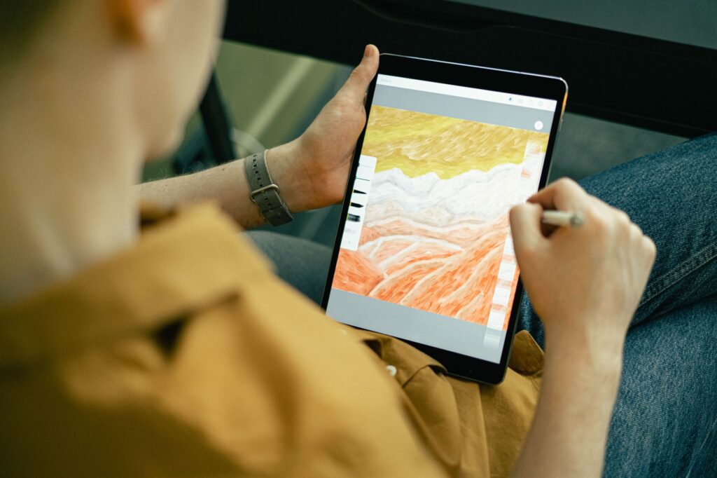 A person sketching colorful digital art on a tablet with a stylus
