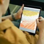 A person sketching colorful digital art on a tablet with a stylus
