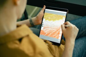 A person sketching colorful digital art on a tablet with a stylus