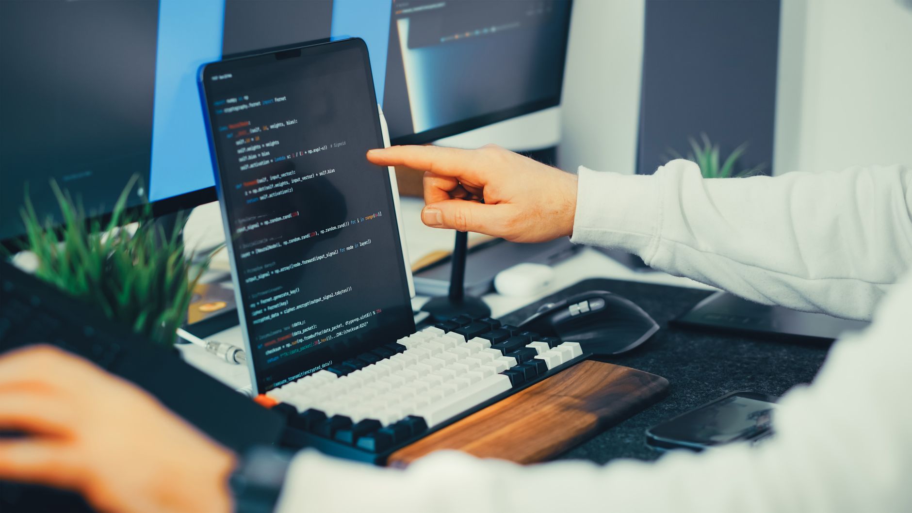 Two developers reviewing code together on a laptop