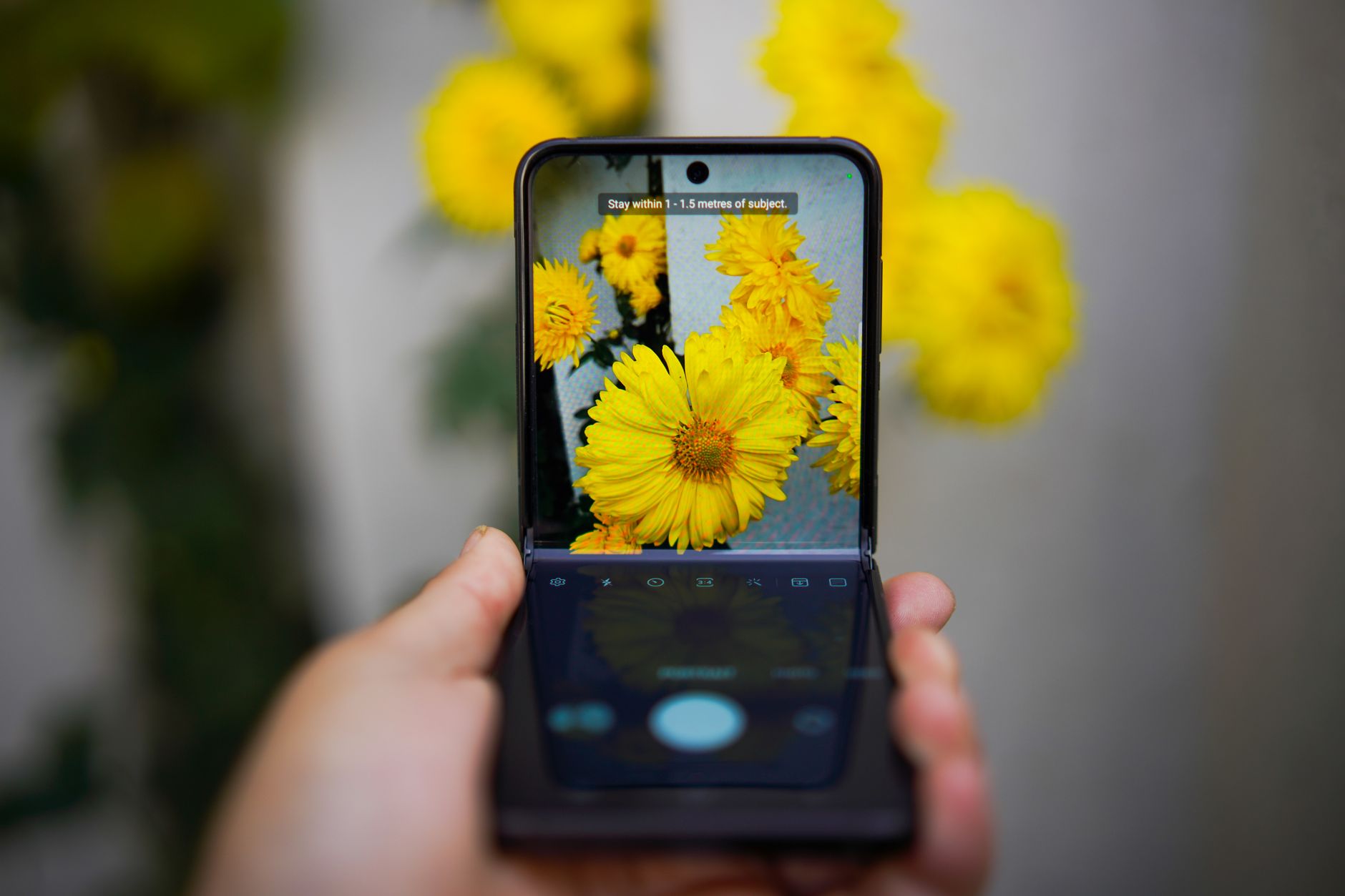 A folding smartphone held open in one hand