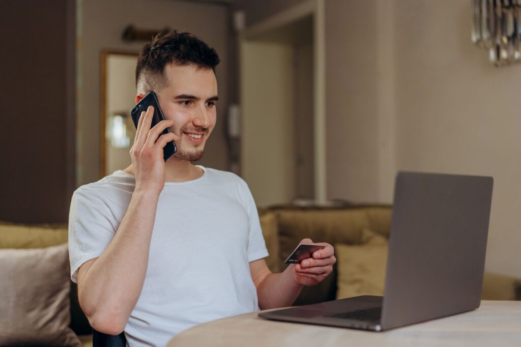 A person using a smartphone and laptop to shop and pay online